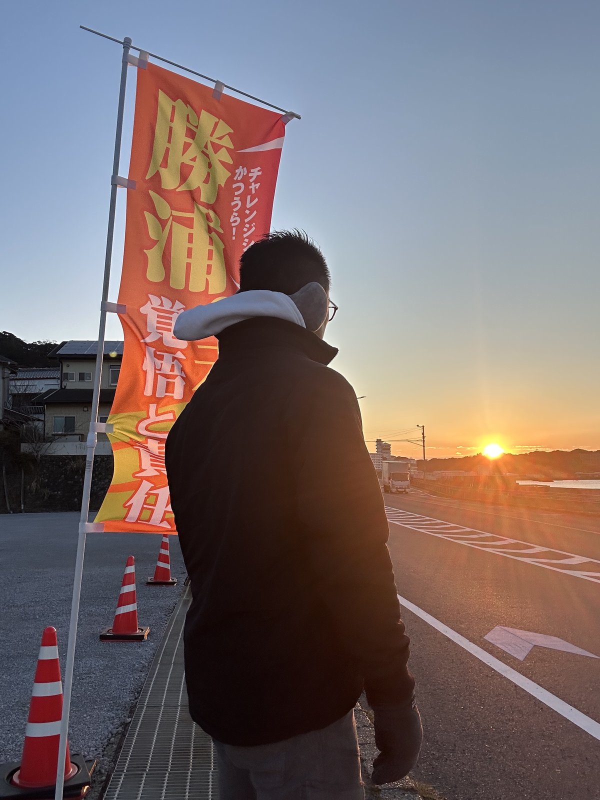 夜明け前、街頭に立つ磯野典正のシルエット